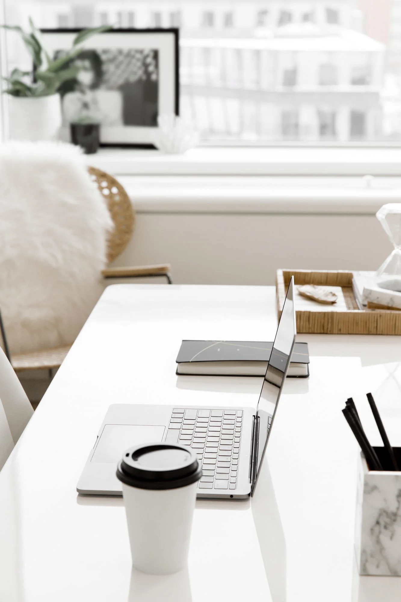 A bright, calm desk with an open laptop, coffee, and a notebook, ready for the next decision.